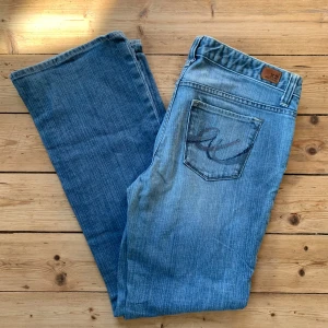Blå jeans från X2 med broderad ficka W34 L30 - Snygga blå jeans från X2 med klassisk femficksdesign och broderad bakficka. Jeansen har rak passform och är tillverkade i denim av bomull. Perfekta för dig som gillar en enkel och stilren look med en liten twist på bakfickan.  Strl: W34 L30