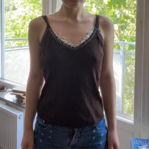 Topp y2k - Mycket bra skick och inget tecken på användning. Materialet är i någon typ av polyester men köpt secondhand. Axelbandet kan justeras med de två knapparna som sitter på baksidan (se bild 5 och 6)