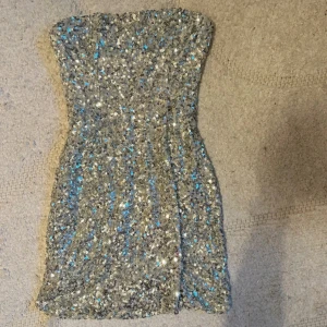 Glittrig silver klänning  - Silver glitter klänning från Nelly använd en gång! Klänningen är i storlek M och sitter så fint på kroppen, den har även ett silikonband som gör att klänningen inte åker ner!!😍  OBS SÄLJER SAMMA KLÄNNING I SVART KOLLA BLAND INLÄGGEN❤️❤️❤️❤️  Finns tillgänglig i Skövde Borås & Värnamo om ni vill slippa frakten🥰❤️