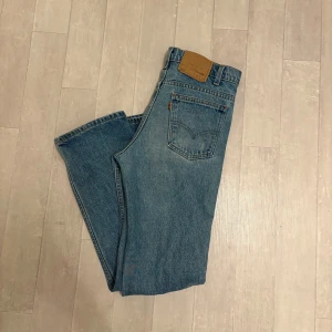 Levi's 501 blå jeans straight fit - Klassiska blå Levi's 501 jeans med rak passform och femficksdesign. Jeansen har mellanhög midja och är tillverkade i robust denim av bomull. Perfekta för dig som gillar en tidlös och avslappnad stil.