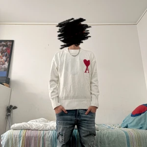 Vit stickad tröja från Ami Paris - Vit stickad tröja från Ami Paris med röd hjärtlogga och bokstaven A på bröstet. Det är fritt fram att ställa frågor ifall du är intresserad pris är inte hugget i sten 