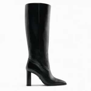 Svarta höga stövlar med klack - Stilrena svarta stövlar i skinn med hög klack och spetsig tå. Klassisk och elegant design som passar perfekt till både kjol och jeans. Stövlarna har en slät yta och når upp till knäet för en snygg siluett.