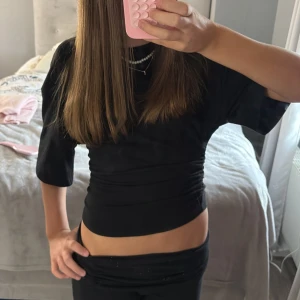 Svart t-shirt med snörning Gina Tricot - Svart t-shirt från Gina Tricot i mjuk bomull med korta ärmar och rund hals. Snygg snörningsdetalj på sidan ger en cool och modern look. Passformen är normal och tyget är slätt och bekvämt. Använd 1 gång, storlek S💞💞