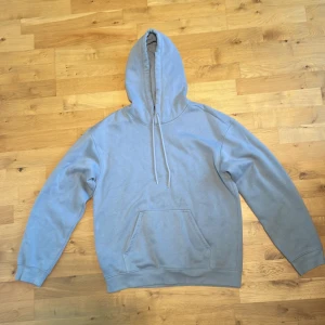 Ljusgrå hoodie från H&M, relaxed fit - En stilren ljusgrå hoodie från H&M i relaxed fit. Tröjan har huva med snörning, magficka och långa ärmar. Jätteskön classic hoodie för en stilren chill look. Storlek: S. Knappt använd.