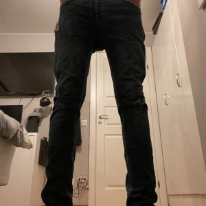 Replay Anbass slim jeans blå - Säljer ett par Replay Anbass jeans i blå tvätt med snygga slitningar och klassiska fem fickor. Jeansen har skinny passform, låg midja och är tillverkade i stretchig bomullsdenim för en bekväm känsla. Perfekta för dig som gillar en smal siluett och stilren look. 32/34