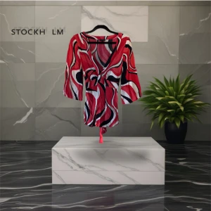 Mönstrad omlottblus från Stockh LM - Snygg kort omlottblus från Stockh lm i rött, svart och vitt med vågigt mönster. Klänningen har v-ringning, trekvartsärm och knytband i midjan. Perfekt för dig som gillar färg och retro vibes.