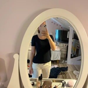 Svart t-shirt från Vero Moda - En stilren svart t-shirt från Vero Moda med rundad hals och korta ärmar. Modellen är figurnära och passar perfekt till jeans eller kjol. Materialet är mjuk bomull som känns skönt mot huden. Enkel och snygg basic som funkar till allt.