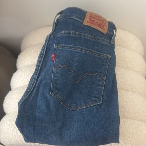 Levi's 720 blå jeans skinny fit - Klassiska Levi's 720 jeans i blå denim med skinny fit. Byxorna har fem fickor, Levi's ikoniska röda etikett och läderpatch bak i midjan. Snyggt smal passform och hög midja, perfekta till sneakers eller boots.