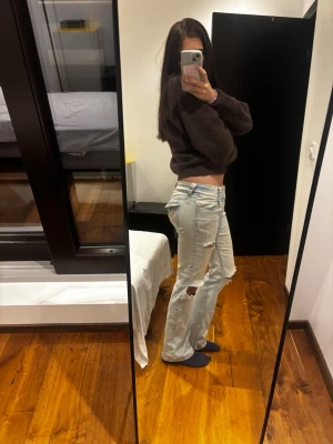 Ljusblå lågmidjade jeans med hål - Säljer mina ljusblå lågmidjade jeans från H&M som jag har klippt hål i själv. De kommer inte till användning längre eftersom jag har flera liknande.