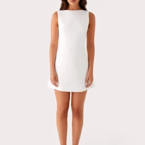 Vit ärmlös kortklänning med öppen rygg - Ny oanvänd jättefin klänning som passar super bra till studenten. Säljer den då jag beställde fel, och inte hann skicka tillbaka den..den är i storlek 38 men skulle passa en 36 då den figursydd!