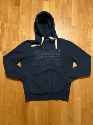 Superdry Hoodie mörkblå - Mörkblå Superdry hoodie! Vintage design (riktigt snygg) Storlek M hör av dig gällande frågor