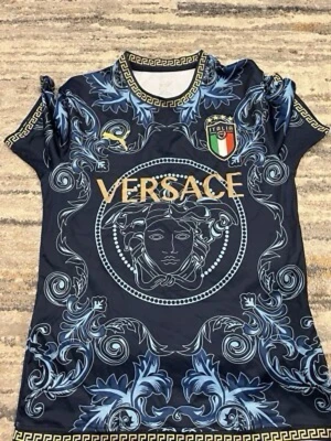  Italien blå topp - Säljer en blå topp Italien-emblem och guldiga detaljer. Toppen har ett unikt barockinspirerat mönster i blått och guld, samt korta ärmar och rund hals med dekorativ kant. Perfekt för dig som vill sticka ut med en lyxig vibe.