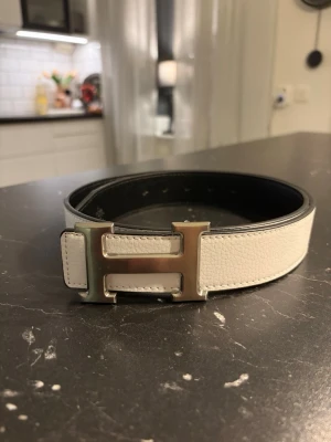 Vitt H-bälte - Säjer ett vitt H-bälte. 110 cm långt men finns möjlighet till att göra hål. Bältet ger en riktigt stilig och erfaren look. Perfekt för dig som söker något elegant i vardagen. Vid frågor är det bara o höra av sig👍☺️
