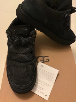 Svarta Ugg lowmels - Allt original följer med (box+extra skosnören) Dem är i mycket bra skick. Ända defekten är en saltfläck på högraskon men går nog bara bort med vatten. Dem är äkta vad jag vet då jag köpte dem av en kille som sa det. Qr koden funkar även Pris kan diskuteras!