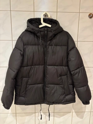 Svart pufferjacka från H&M - Säljer en svart pufferjacka från H&M i storlek S, den är oversized. Liten reva på ena armen, se bild.