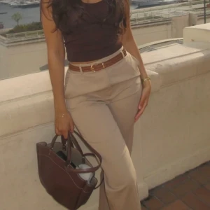 Beiga kostymbyxor med bälte - Snygga beiga kostymbyxor med medel hög midja och raka ben. Perfekta för en clean och stilren look. 