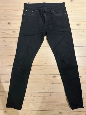 Levi's 512 svarta skinny jeans - Säljer ett par svarta Levi's 512 jeans med klassisk femficksdesign och smal passform. Jeansen har en skinny siluett, normal midja och är tillverkade i stretchig denim för extra komfort. Perfekta till sneakers eller boots.