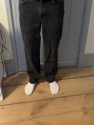 Svarta raka jeans från ASOS DESIGN - Säljer ett par svarta jeans från ASOS DESIGN med rak passform och klassisk femficksmodell. Jeansen har normal midja. Perfekta för dig som gillar en clean och enkel look.