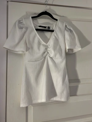 Vit v-ringad topp - Säljer en vit snygg blus från Vero Moda. Den har bara andvänds ett fåtal gånger💕