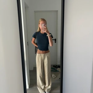 Lågmidjade kystymbyxor från Zara - Säljer ett par beiga kostymbyxor med låg midja. Endast använda en gång och i nyskick. Materialet är linne och färgen är ljusbeige. Storlek xs. Passar bra i längden på mig som är 176cm lång❤️