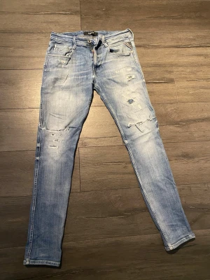 Replay  jeans med fabrikslitningar  - Säljer ett par ljusblå Replay jeans med slitningar  på benen. Perfekta för dig som gillar en avslappnad men trendig look. Priset är diskuterbart via snabb affär. Inga defekter eller likande. W32 L34
