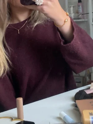 Vinröd stickad tröja - Mysig vinröd stickad tröja med rund halsringning och långa ärmar. Perfekt för lager på lager och passar till både jeans och kjol. Enkel och stilren design som funkar till det mesta. Passar bättre på en som bär storlek  S/M