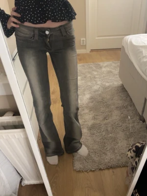 Grå bootcut jeans från Cheap monday - Säljer ett par grå bootcut jeans från Cheap monday i storlek 25/32. Jeansen har en snygg tvättad look, klassiska fem fickor och låg midja. Materialet är stretchigt med 70% bomull, 28% polyester och 2% elastan. Perfekta för en avslappnad och trendig stil.