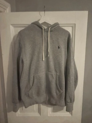 Polo Ralph Lauren hoodie  - En grå Polo Ralph Lauren hoodie. Tjockt och skönt material, mycket bra nu för kalla tider. Köpt för något år sedan och änvänt den en hel del men mycket bra kvalité, inte en skråma på den. 