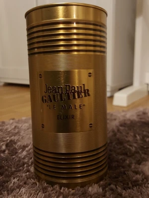 Le Male Elixir limited edition - Snygg och lyxig parfym från Jean Paul Gaultier i guldig design. Perfekt för dig som vill sticka ut med en ikonisk flaska i samlingen. Namnet 'Le Male Elixir' syns tydligt på förpackningen.