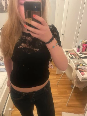 Svart spetsblus med kort ärm - Säljer en svart blus i spets med korta ärmar och rund hals. 