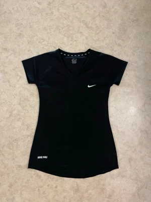 Nike Dri-FIT Black V-Neck T-Shirt – Size M – Brand New (Tag Detached) - Brand new Nike Dri-FIT black V-neck T-shirt, size M (size label clearly visible on photos). The shirt has never been worn and is in perfect condition. Please note: the original price tag has come off, but the item is 100% new and unused. Made from lightweight, breathable Dri-FIT  Clean and minimal design with a white Nike swoosh on the chest. ✔ Size: M ✔ Condition: Brand new ✔ No stains, no damage, no wear Feel free to message me if you have any questions