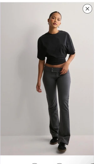 Nelly lågmidjade kostymbyxor  - Snygga mörkgrå bootcut kostymbyxor från Nelly med två knappar i midjan och stretchigt material. Har XXS men passar XS💕 Pris kan diskuteras 