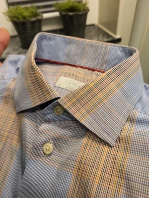 Rutig skjorta från Eton i bomull 40 15.75 - Snygg rutig skjorta från Eton i bomull med klassisk krage och knappar framtill. Skjortan har ett mönster i blått, beige och inslag av gult och brunt. Långärmad modell med manschettknappar och modern passform.