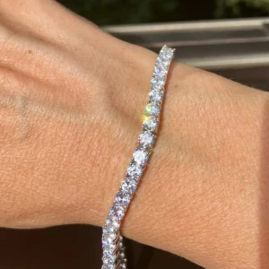 Glittrigt tennisarmband i silver - Diamantarmband äkta silver. Snyggt tennisarmband med briljantslipade stenar. Armbandet har en klassisk och stilren design som verkligen blänker i ljuset. Perfekt för dig som gillar att sticka ut med lite extra bling på handleden. Längd: ca 18 cm Bredd:5mm. Priset är inte hugget i sten så kom gärna med förslag.