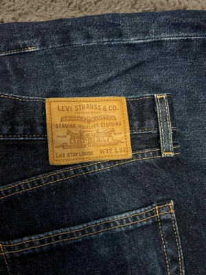 Levi's Stay Loose jeans mörkblå W32 L32 - Mörkblå Levi's Stay Loose jeans med klassisk femficksdesign och raka ben. Snygga kontrastsömmar och läderpatch bak i midjan. Jeansen har en loose fit och är tillverkade i robust denim för en avslappnad look.