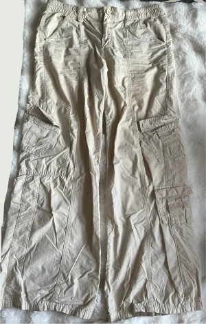 Beige cargo byxor från Urban outfitters - Några tecken på användning såsom slitage vid foten. Storlek S-M