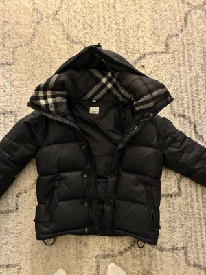 Burberry Jacka - Mycket bra skick, ingen skador. Armarna går löst så det blir till en Väst. Storlek S säljer den på grund av att jag behöver pengar. 