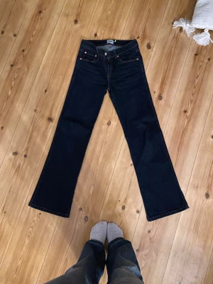 Mörkblå lågmidjade bootcut jeans - Mörkblå lågmidjade bootcut jeans från 157 med klassisk 90-talsvibe. Snygga bakfickor med silverfärgade knappar. Jeansen har en rak passform upptill och utsvängda ben, skulle säga att storleken är XS