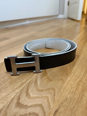 Bälte med H-spänne - Snyggt bälte med H-spänne. Vändbart mellan svart och vitt, 115cm. Armband medföljer!