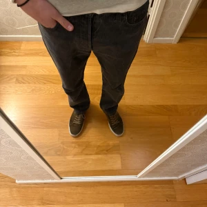 Levi's 501 mörkgrå jeans straight fit - Säljer ett par Levi's 501 jeans i mörkgrå tvätt med klassisk straight fit. Jeansen har fem fickor, knappgylf och den ikoniska Levi's-lappen bak. Perfekt för dig som gillar en tidlös och chill look.