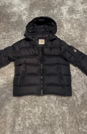 Moncler Marque Giubbotto - Moncler dunjacka med luva som är avtagbar genom dragkedjan. Jackan har NFC och är äkta och knappast använd. Jackan köptes på Plick för 3000kr.