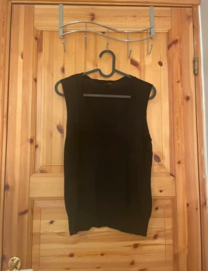 Svart stickad väst med v-ringning - Svart stickad väst med snygg v-ringad hals. .