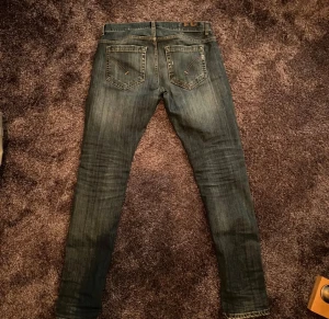 Dondup george w:31  - Säljer ett par dondup mörkblå med slitningar och små hål på benen. Skinny fit med låg midja och klassiska fem fickor. Snygga detaljer på bakfickan och kontrastsömmar. Perfekta för dig som gillar en smal siluett. Funkar vid alla årstider och platser, fet julklapp för brorsan elle för sig själv. Ny priss runt 3200 mitt pris :750kr 