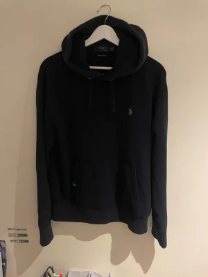 Ralph Lauren hoodie  - Mörkblå Ralph luren hoodie med grönt märke och detalj vid fickan. M men passar S