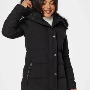 Hollies Subway - Säljer en svart lång pufferjacka från Hollies med stor huva och fuskpäls. Jackan har dragkedja och knappar framtill, två fickor med dragkedja och quiltad design. Perfekt för kalla dagar och riktigt snygg till vintern. Storlek Xs 