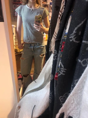 Randig svartvit t-shirt med kort ärm - Snygg t-shirt med smala svarta och vita ränder, rund hals och korta ärmar. Modellen är klassisk och passar perfekt till jeans eller shorts. Materialet är mjukt och skönt bomull, vilket gör den bekväm att ha på sig hela dagen.