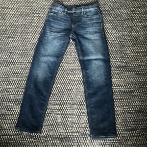 Jack & Jones Tapered Mike jeans blå - Snygga blå jeans från Jack & Jones, modell Tapered Mike. Jeansen har klassisk femficksdesign, ljusare tvättade partier och kontrastsömmar. Tillverkade i bomull med en tapered passform som smalnar av nedtill. Perfekta för en avslappnad och trendig look.