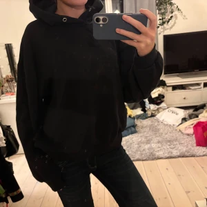 Svart hoodie med huva - En svart over sized hoodie med huva och snörning i halsen. Tröjan har en loose passform och långa ärmar med ribbade muddar. Supermysig och skitsnygg. Perfekt för vinterhalvåret!