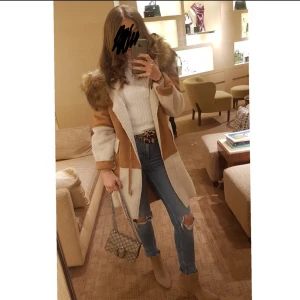 Beige teddyjacka med fuskpäls - Säljer en snygg beige teddyjacka med bruna detaljer och stor huva med fuskpäls. Jackan har lång ärm och dragkedja framtill. Perfekt för dig som gillar mysiga och trendiga ytterplagg med coola detaljer.