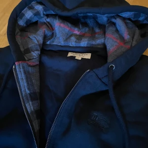 Burberry zip hoodie - Burberry zip hoodie i strlk S | Endast testad men passade tyvärr inte | Mycket fin kvalité och har sin ikoniska rutiga färg | Skriv till mig för fler funderingar!